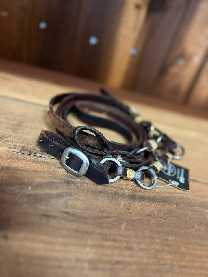 Dark oil smooth leather roping reins with 2 rings and rawhide buttons and buckle quick change ends.